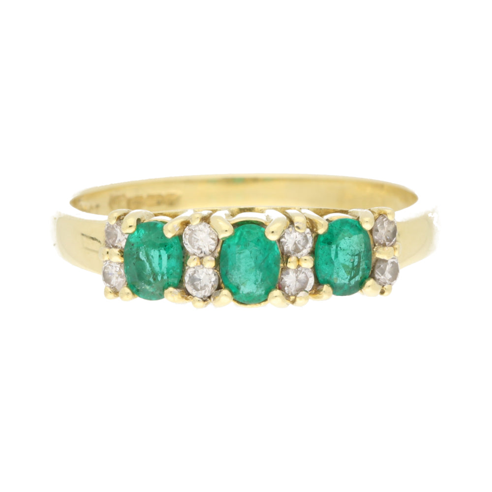Pre-Owned Gold ring with emeralds and diamonds on a white background